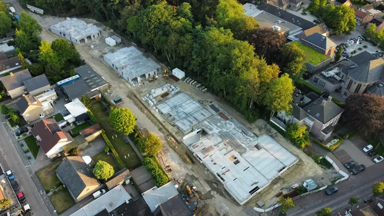 Luchtfoto van de bouwplaats van 't Rozenquartier. De contouren van de appartementencomplexen worden al goed zichtbaar in de groene omgeving van Sprundel.